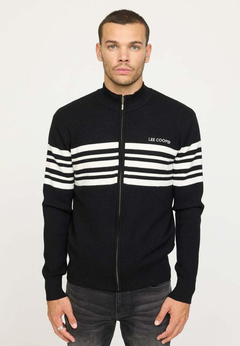 Veste zippée noire avec un col montant, ornée de rayures horizontales blanches et du logo "LEE COOPER" sur le devant. Texture tricotée.