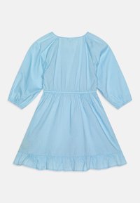 Robe bleu clair à manches longues avec un col rond, une taille froncée et un ourlet volanté. Fabriquée en tissu coton texturé.