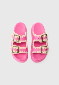Rosa sandaler med to justerbare spennegjemmer, som har et teksturert design og kontrasterende kremfargede detaljer langs kantene.