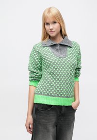 Pletený pulóver v zelenej a sivej farbe s textúrovaným vzorom. Má veľký sivý rebrovaný golier a voľný strih so zelenými manžetami a lemom.