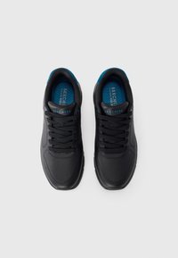 Chaussures de sport noires avec un dessus en cuir lisse, des accents en maille, des semelles intérieures bleues et un design à lacets. Elles possèdent une semelle en caoutchouc épaisse pour un bon amorti.