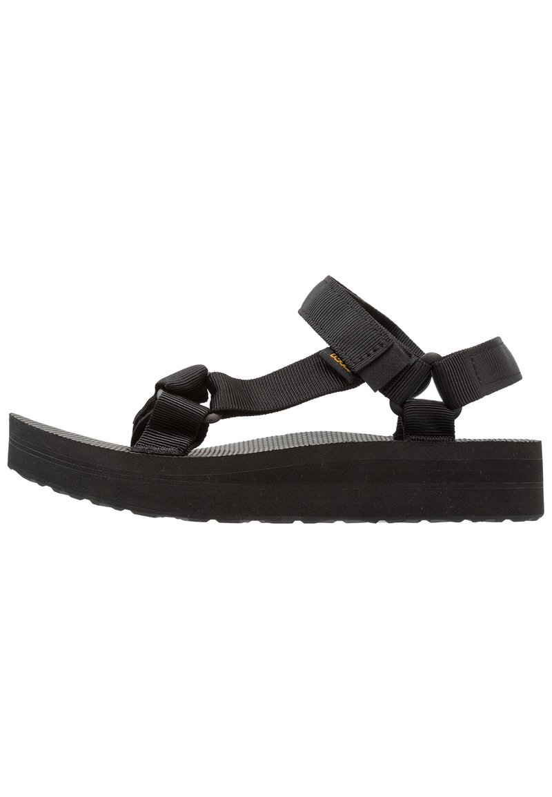 Black sandals featuring adjustable nylon straps, a chunky rubber sole, and textured footbed for enhanced grip. Lightweight, open design.