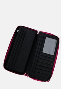 Portafoglio in pelle nera con cerniera rosa, diverse fessure per schede, una finestra trasparente per l'ID e una superficie liscia. L'interno presenta un design minimalista.