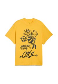 Gul bomulds t-shirt med en sort grafik af en bi med en fodbold, teksten "Manchester Calling" og "0161" nedenfor. Korte ærmer, løs pasform.