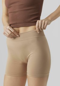 Shorts beige senza cuciture con una morbida cintura a coste, realizzati in tessuto elastico, progettati per comfort e flessibilità.