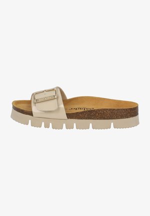 Beige slide sandals with a glossy strap featuring a square buckle. Cork footbed and textured rubber sole provide comfort and traction.