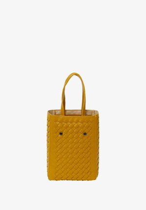 Geflochtene Leder-Shopper-Tasche in leuchtendem Gelb mit zwei kurzen Griffen, strukturiertem Muster an den Seiten und zwei dekorativen schwarzen Nieten auf der Vorderseite.