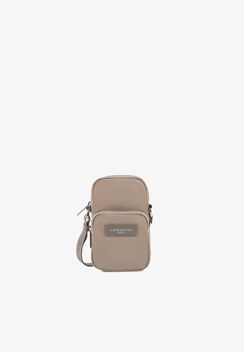 Petit sac beige rectangulaire porté en bandoulière avec poche zippée à l’avant et étiquette « Lancaster Paris », bandoulière réglable sur fond blanc.