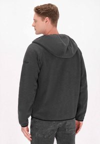 Mörkgrå huvtröja i mjuk fleece, med en enkel design, elastiska ärmslut och en subtil logotyp på ärmen.