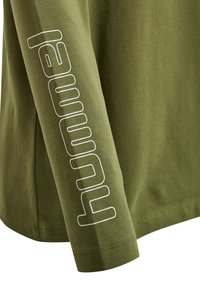 Langærmet olivengrøn skjorte med en blød bomuldsstruktur, der har et hvidt "hummel" logo trykt lodret langs ærmet.