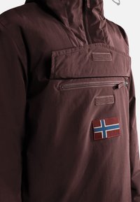 Felpa color bordeaux con tasca frontale con cerniera, caratterizzata da una toppa della bandiera norvegese. Realizzata in materiale liscio e leggero.