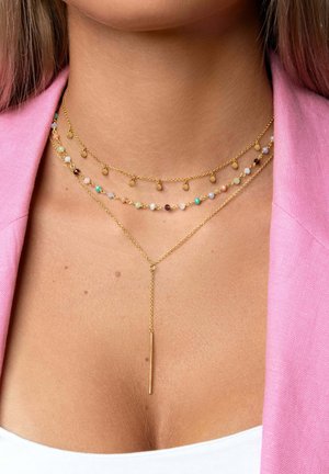 Collier en or à trois couches avec des perles colorées entrecoupées de petits accents dorés, présentant une chaîne en or plus longue au centre.