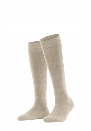Chaussettes beiges hauteur genou avec des bords côtes, texture en tricot lisse et orteils renforcés, présentées verticalement sur un fond blanc.