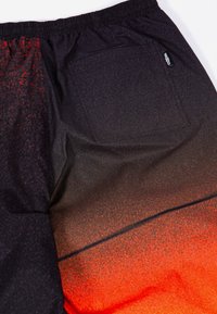 Čierne šortky s oranžovým gradientným dizajnom. Majú elastický pás a zadnú vrecko s etiketou. Vyrobené z hladkého, ľahkého materiálu.