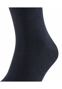 Calzino blu navy con una texture a costine e una vestibilità aderente, con una caviglia liscia e un sottile accento blu vicino alla punta.