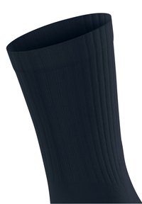 Czarna skarpetka z prążkowanym wzorem w pionowe tekstury, widoczna na gładkim białym tle.