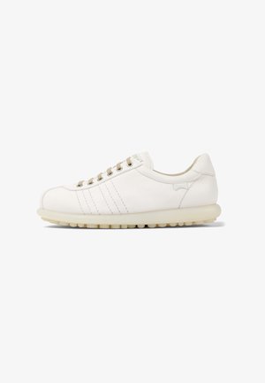 Zapatilla de cuero blanco con punta redondeada, seis ojales, cordones de color marrón claro y detalles de costura sutiles. Presenta una suela de goma texturizada.