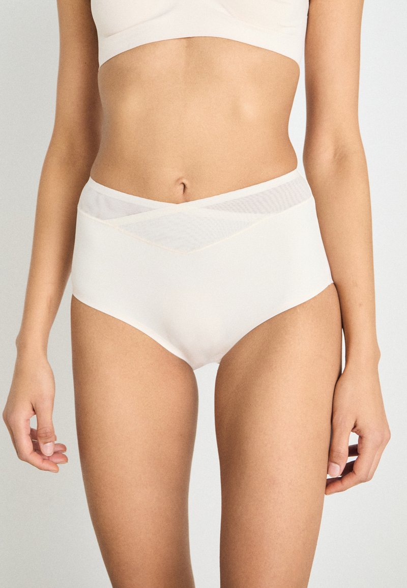High-waisted beige underwear with a sheer textured waistband, smooth fabric, and subtle detailing along the edges.