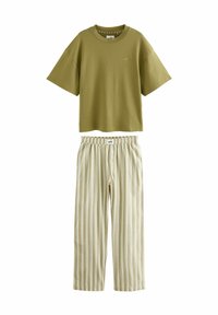 Oliwkowa bawełniana koszulka z krótkim rękawem w połączeniu z jasnymi, szerokimi spodniami w paski z regulowanym paskiem w talii i detalami na guzik.