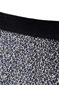 Tissu imprimé léopard dans des teintes de bleu et noir, avec une taille élastique noire comportant du texte en relief, texturé et doux au toucher.