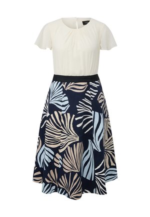 Ivory shirt met korte mouwen gecombineerd met een marineblauwe rok met beige en lichtblauwe tropische bladpatronen en een zwarte tailleband.