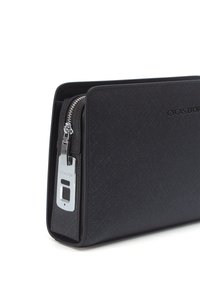 Clutch rettangolare nera realizzata in materiale sintetico testurizzato, con una zip e hardware argentati e dettaglio del logo sul fronte.