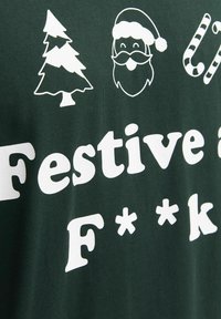 Tamnozeleni T-shirt s bijelim grafikom koja prikazuje božićnu drvce, lice Djeda Mraza, slatiše i tekst "Festivno & J****". Pamuk.