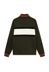 Dunkelgrüner Strickpullover mit hohem Kragen. Er zeichnet sich durch auffällige horizontale Streifen in Schwarz und Weiß aus, mit roten Akzenten am Kragen und an den Bündchen.