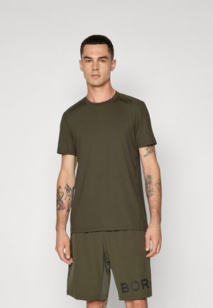 Oliven grønn treningst-skjorte med korte ermer, rund hals og logodetalj på skulderen, sammen med matchende shorts med logoprinter.