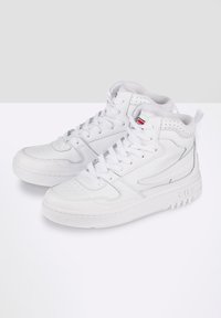 Zapatillas altas blancas, hechas de cuero liso, con detalles perforados, cierre de cordones y suela de goma texturizada. Logo de Fila en el costado.