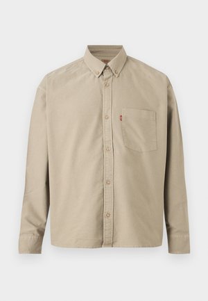 Bež bežna srajca z dolgimi rokavi, z gumbi na sprednji strani, ovratnik z gumbi, prsni žep na levi strani in viden rdeč trak na šivu žepa.