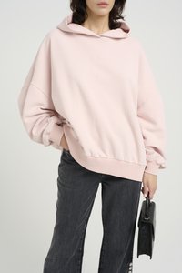 Svetlo roza oversized kapuca z sprednjo kengurujčko žepom in rebrastimi manšetami. Ujemajoča se s temno sivo širokimi hlačami in črno torbico.