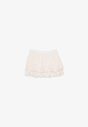 White lace mini skirt with a layered design, featuring a textured surface and an elastic waistband for comfort.