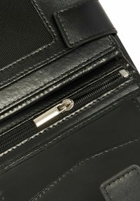 Czarny skórzany portfel o wykończeniu na połysk, wyposażony w zamknięcie na zamek błyskawiczny, teksturowane akcenty oraz przeszycia na krawędziach.