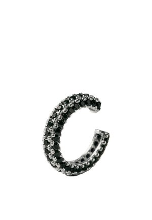 Anillo abierto de plata con tres filas de pequeñas piedras negras colocadas en un patrón, diseñado como una banda curva sobre un fondo blanco.