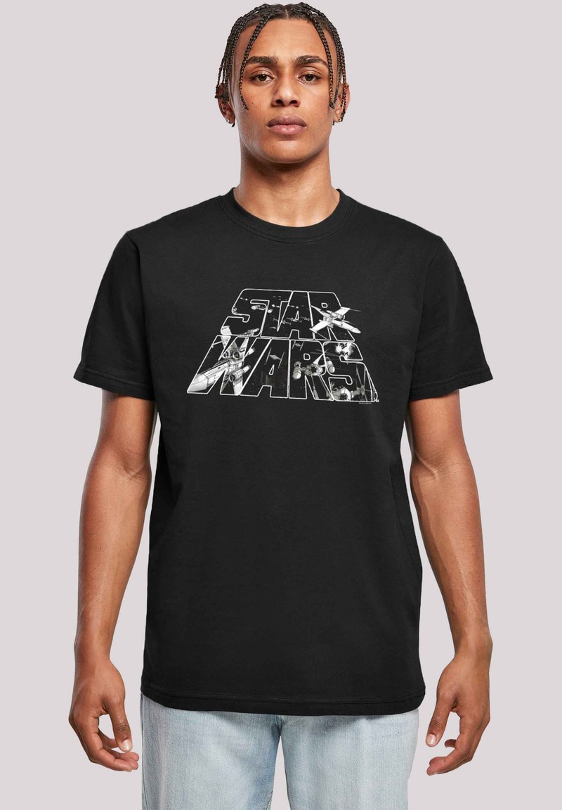 Svart bomull t-skjorte med et stort hvitt grafikk av "Star Wars"-logoen og romfartøy-design. Rund hals, korte ermer.