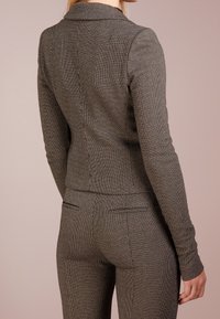 Skräddarsydd grå och svart houndstooth-blazer med notch-krage, texturerad tyg, slim fit och två bakventiler.