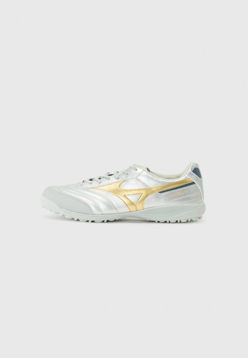 Pantofii sport argintii cu un finisaj lucios, accente aurii, talpă texturată gri și toc albastru contrastant; au un design cu șireturi și detalii cu logo.