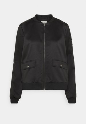 Giacca bomber nera con cerniera frontale, due tasche con patta e bottone a pressione, collo, polsini e orlo a costine e tasca con cerniera sulla manica sinistra.