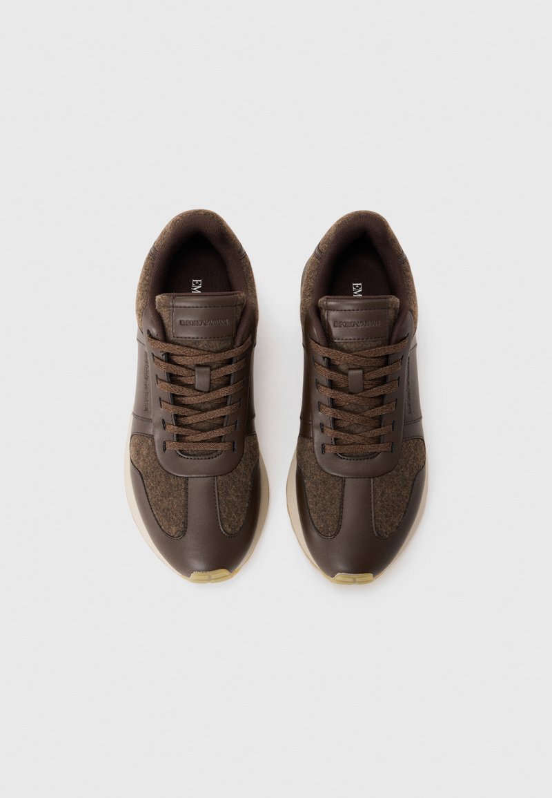 Bruine sneakers met een combinatie van glad leer en textiel met een structuur. Ronde neus, platte veters en een lichtgekleurde rubberen zool.