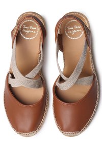 Espadrillas in pelle marrone con una fascia elastica incrociata beige testurizzata e suola in juta, caratterizzate da punta tonda e dettagli di cucitura minimi.