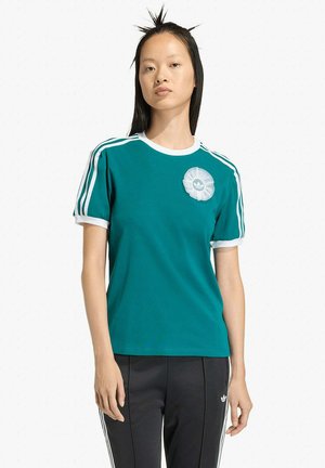 T-shirt teal a maniche corte con rifiniture bianche e tre strisce bianche sulle spalle. Presenta un logo a forma di fiore blu traslucido sul petto.