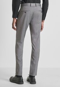 Sive krojene hlače s suptilnim uzorkom, koji imaju uski kroj, prednje džepove i dva stražnja džepa s kopčama na dugmad.