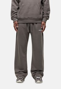 Grijze katoen sweatshirt en bijpassende joggingbroek met zijzakken. De joggingbroek heeft een tailleband met trekkoord en een klein logo op het been.