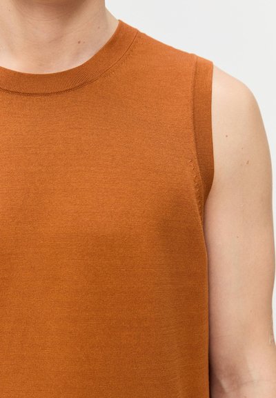 Chemise en coton orange sans manches avec un col rond côtelé et une texture lisse, présentant des détails de couture minimaux au niveau de l'emmanchure.