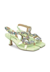 Sandalias de charol verde claro con un tacón bajo. Presentan un diseño de tira decorativa con gemas multicolores y un estilo de punta abierta.