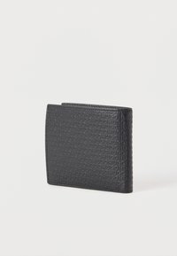 Μαύρο δερμάτινο πορτοφόλι με ανάγλυφο επαναλαμβανόμενο μοτίβο κειμένου "HUGO", εμφάνιση κλειστό πάνω σε απλό λευκό φόντο.