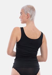 Black sleeveless top made of soft fabric, featuring a rounded neckline and fitted design. The back showcases a smooth texture with no visible seams.