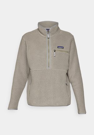 Veste en polaire taupe clair avec un col montant, fermeture zippée demi-longueur à l'avant et une poche poitrine zippée. Caractéristiques d'un tissu texturé et d'une finition grise contrastante.