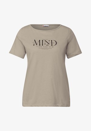 Béžové tričko s krátkým rukávem vyrobené z měkkého materiálu, na přední straně s velkým grafickým potiskem a textem 'UDĚLEJTE ZE SVÉ MYSLI PĚKNÉ MÍSTO, KDE MŮŽETE BÝT'.